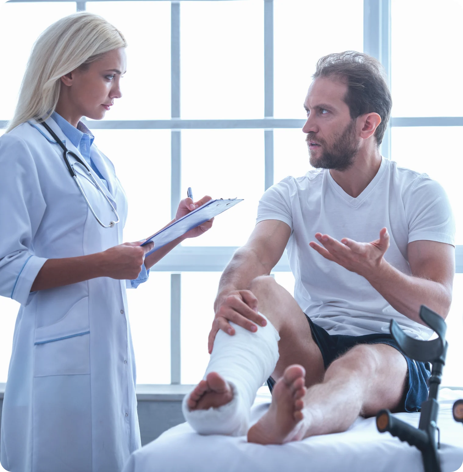 Doctor reviewing a patient's injured leg during an exam