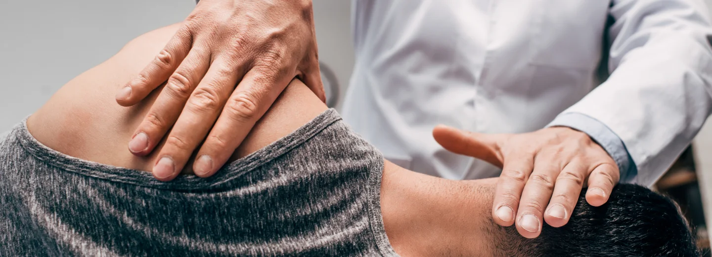 Chiropractor examining a patient's shoulder