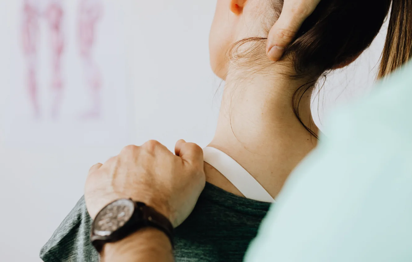 Patient holding her sore neck and shoulder